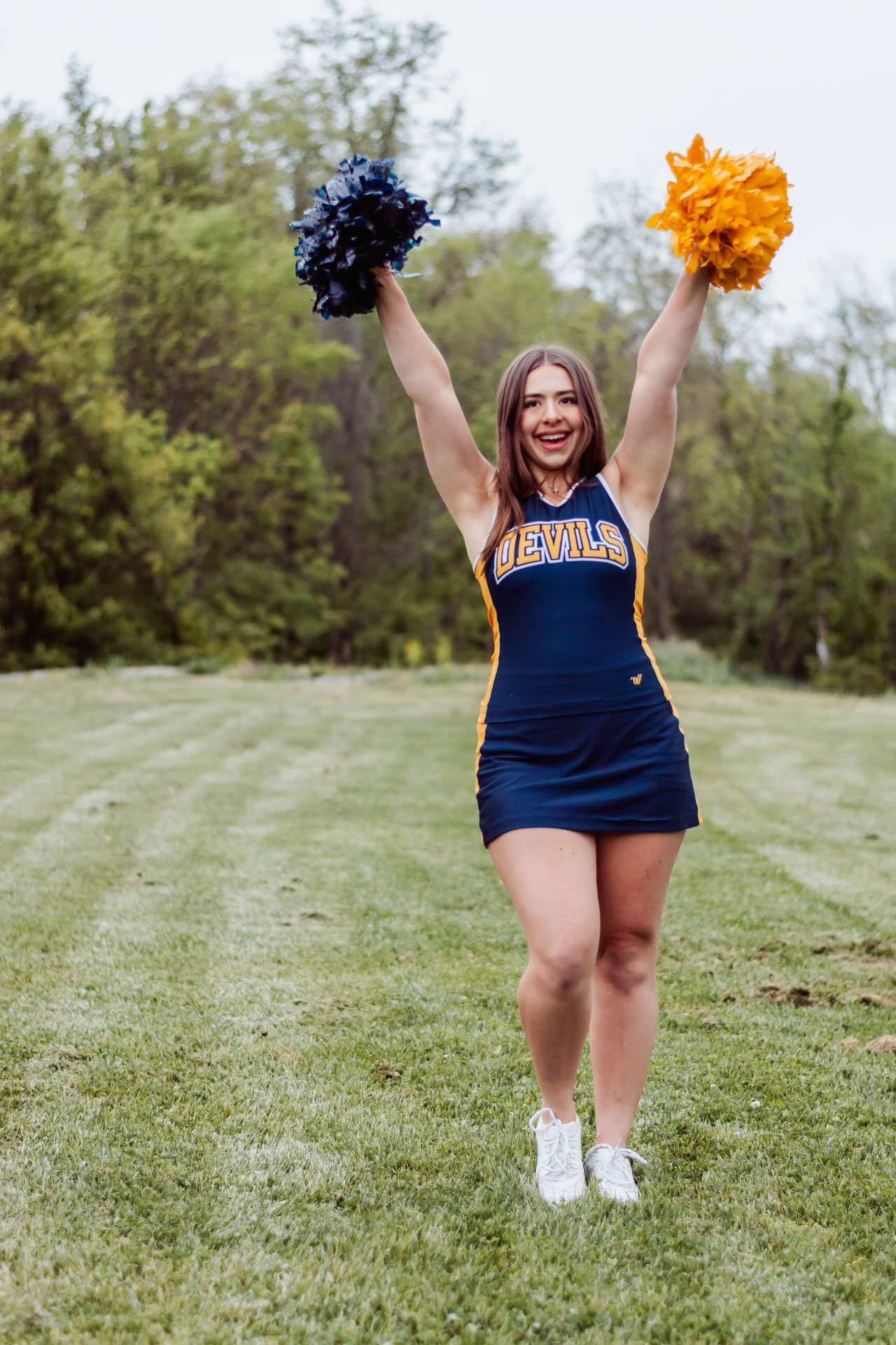 Senior portrait featuring a cheerleader with pom-poms near Pittsburgh